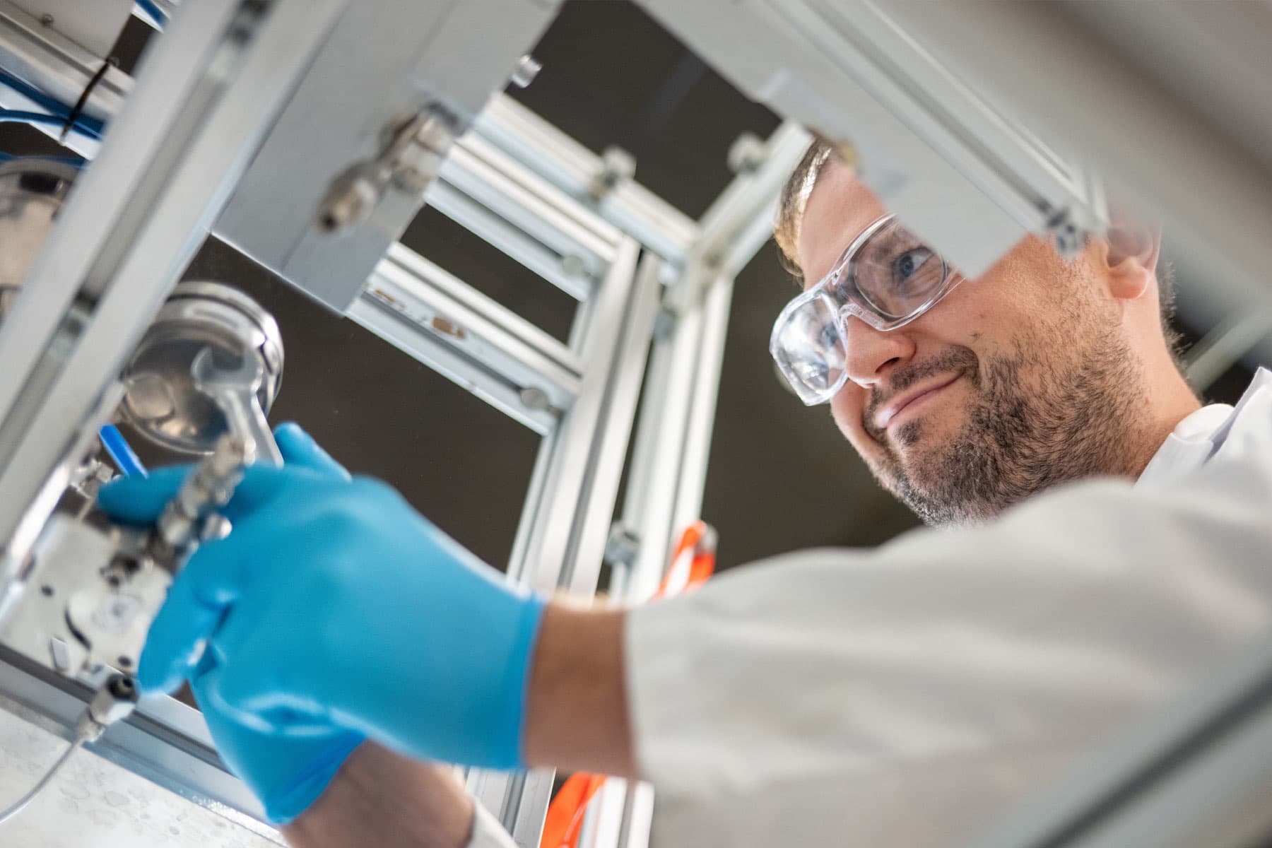 Greentown member in safety glasses machining a hardware prototype in the lab