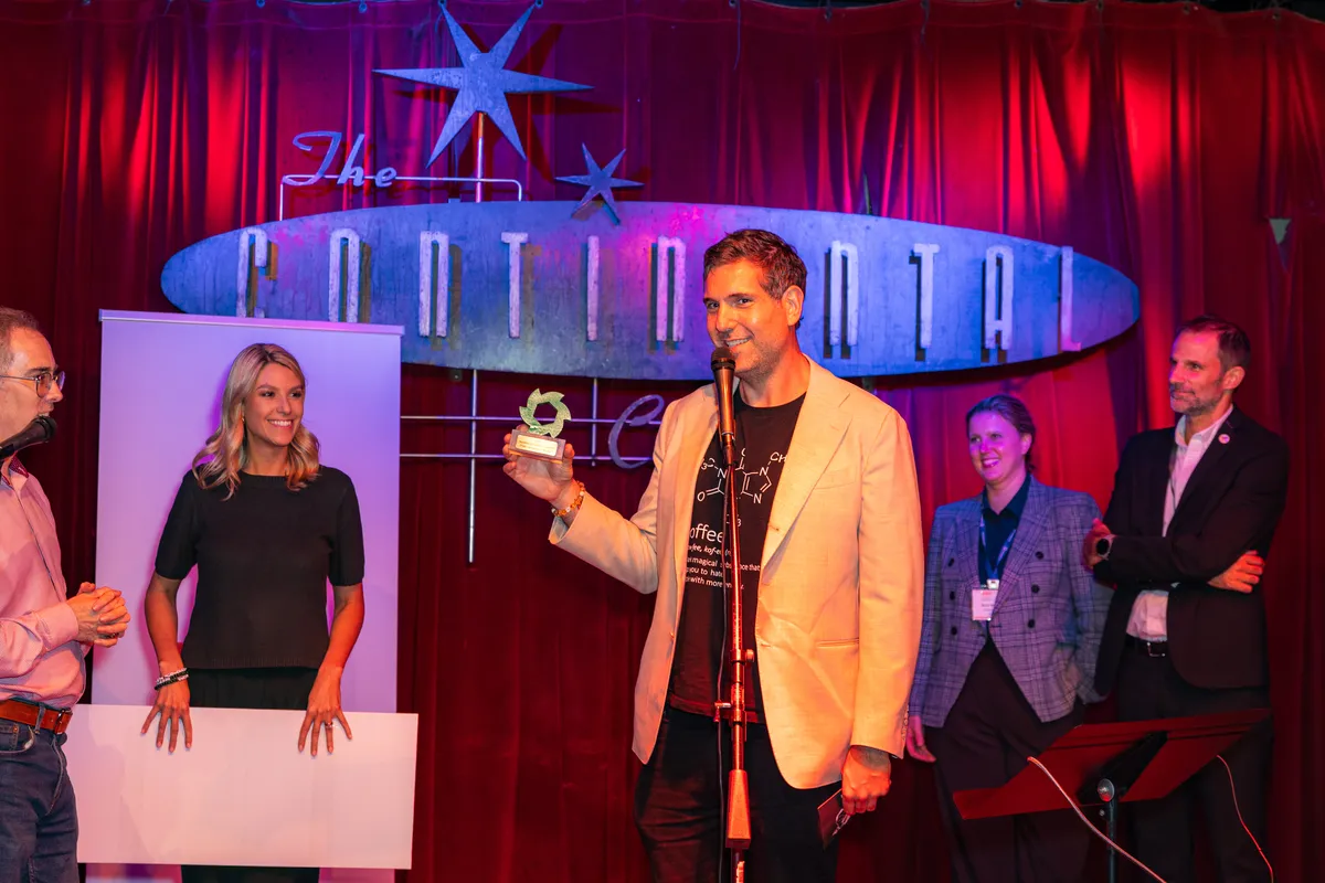 Matt Myers shows off a custom award on stage at Continental Club